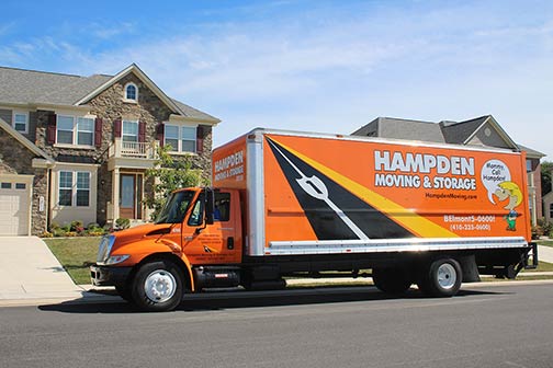 long distance moving truck parked in front of home
